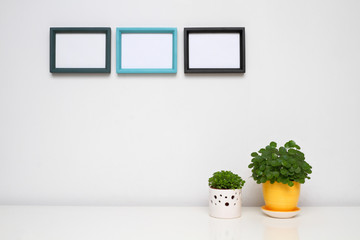 Three photo frames on white wall.