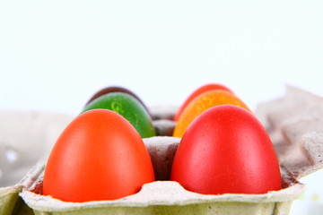 Colorful eggs in a carton
