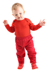 Baby girl dressed in red learning to walk isolated on white