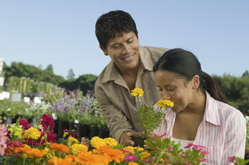 couple shopping at plant nursery smelling flowers