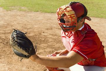 baseball catcher crouching on baseball field