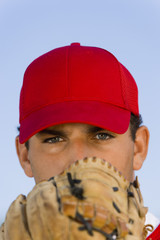 baseball pitcher holding glove in front of face (close-up) (portrait)