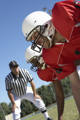 referee watching football players on field
