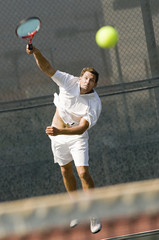 Fototapety  mężczyzna serwujący piłkę tenisową na siatce tenisowej