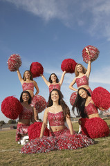 cheerleaders posing with pom poms in group