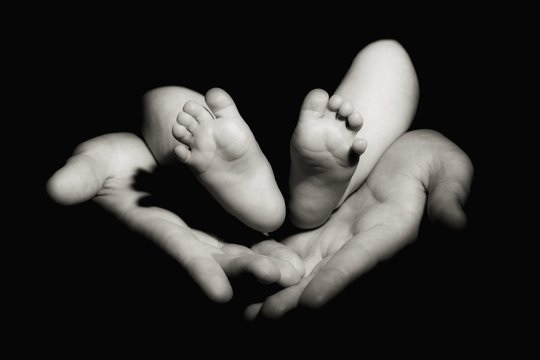 Adult hands and baby feet