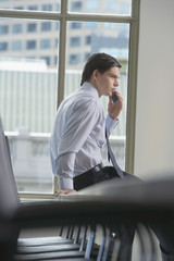 businessman using mobile phone in office side view