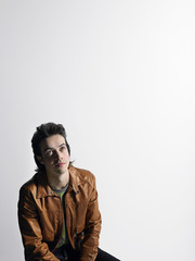 man wearing leather coat sitting in studio