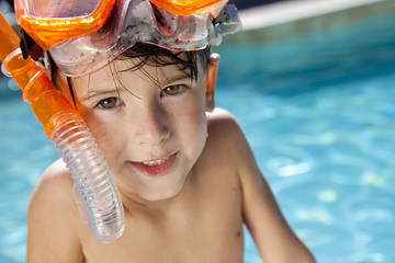 Happy Boy In A Swimming Pool with Goggles and Snorkel