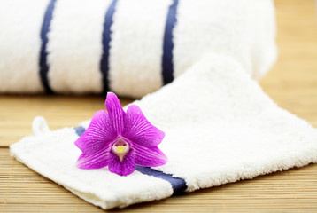 Fototapeta na wymiar masażu zen wystrój, Orchidea, ręczniki, rękawiczki, bambus w tle
