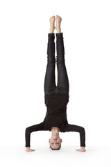 Teenage girl in headstand on white background
