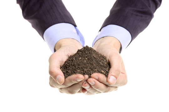 Hands holding a pile of soil isolated against white background