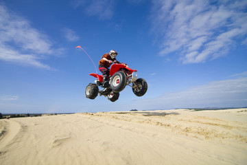 quadbike jumping dunes - obrazy, fototapety, plakaty