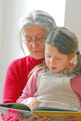 Enkelin liest der Oma etwas vor