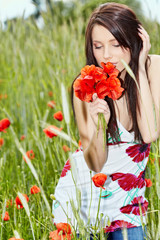 Obraz na płótnie Canvas Pretty woman in poppy flowers