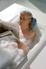Baden, Opa in der Badewanne liest Zeitung