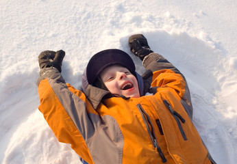 Fototapeta na wymiar The child cheerfully plays to snow