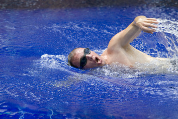 Fototapeta na wymiar The young sports swimmer in pool