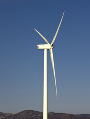 windmil in the top of a montain with blue sky, alternative energ