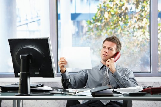 Businessman  on call looking at paper