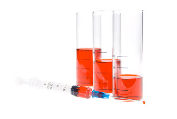 tubes and syringe with red liquid  on a white background