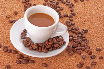 Small white  cup of coffee with coffee grain   on brown backgrou