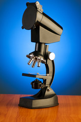 Microscope against blue gradient background