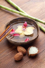 flower in ancient wood bowl with burning incense spa concept
