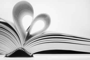 opened book with pages folded in heart shape