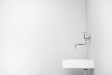 Sink in an empty big white room.