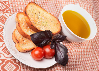Toasts, olive oil, basil grass and tomatos