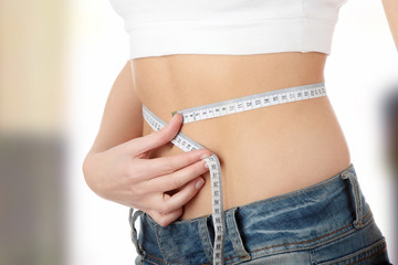 Sexy, fit, young woman measuring