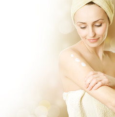 Beautiful Young Woman applying moisturizer.Skincare concept