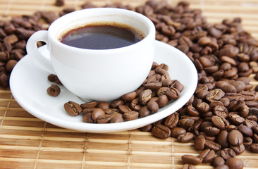 cup of coffee on a background coffee-beans and bamboo serviette
