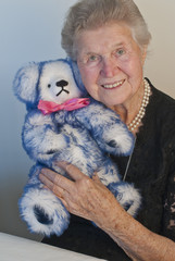 Senior lady in her eighties cuddling teddy bear