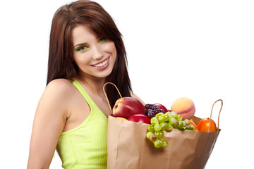 woman holding a  bag full of fresh and healthy food.