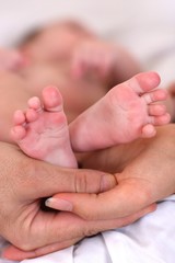 Obraz na płótnie Canvas małe stopy dziecka w rękach rodziców