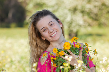 Naklejka premium Beautiful young woman standing in blooming meadow