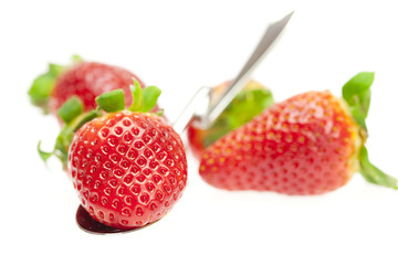 juicy strawberries on spoon isolated on white