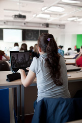 young pretty female college student sitting in a classroom full