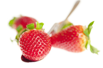 juicy strawberries on spoon isolated on white