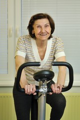 Fototapeta na wymiar Spinning senior fitness woman indoors