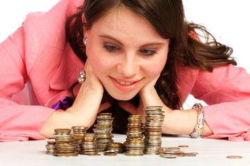 A young woman watching stacks of coins