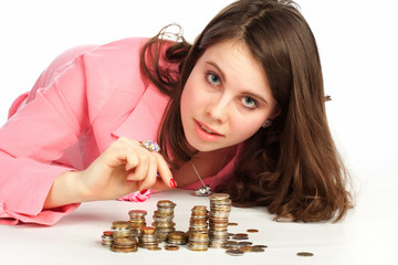 A young woman touching stacks of coins