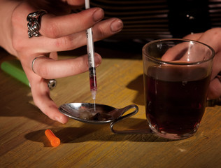 Drawing black tar heroin into a needle