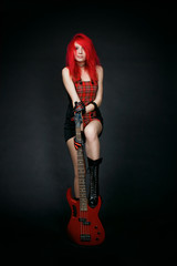 Redhead rocker girl with bass guitar