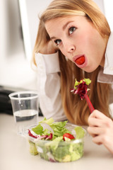 Obraz na płótnie Canvas junge hübsche Frau beim Salat essen