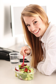 junge h&uuml;bsche Frau beim Salat essen