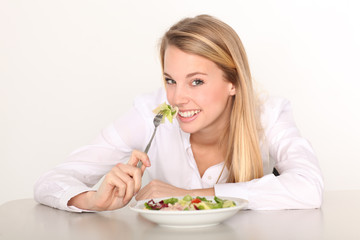 junge hübsche Frau beim Salat essen