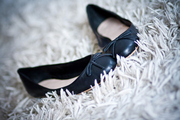 schwarze Ballerinas auf einem weißen Teppich